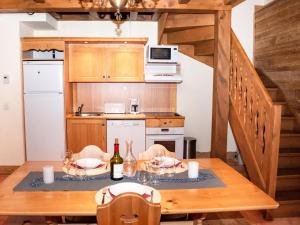 eine Küche mit einem Holztisch mit 2 Flaschen Wein in der Unterkunft Charmant Chalet 6 Pers. avec Terrasse et Parking - Résidence Les Chalets de Praroustan, Pra Loup 1500 - FR-1-504-364 in Uvernet + 6 Fotos