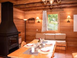 ein Wohnzimmer mit Tisch und Kamin in der Unterkunft Charmant Chalet 6 Pers. avec Terrasse et Parking - Résidence Les Chalets de Praroustan, Pra Loup 1500 - FR-1-504-364 in Uvernet