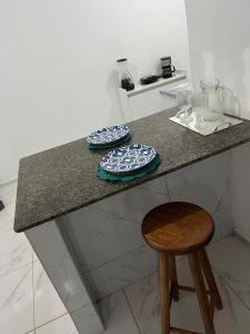 a kitchen counter with two plates and a stool at Apartamento da Kenia in Canoa Quebrada +22 photos