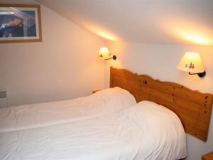 une chambre avec deux lits avec des draps blancs et des lampes dans l'établissement Chalet Duplex 8 Pers, 300m des Pistes, Terrasse, Piscine Couverte, Parking - FR-1-504-435, à Superdevoluy 15 autres photos