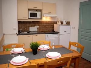 une cuisine avec une table en bois et des chaises ainsi qu'une salle à manger dans l'établissement 3 Pièces pour 6 pers. avec cuisine équipée à Superdevoluy - FR-1-504-454, à Superdevoluy 15 autres photos