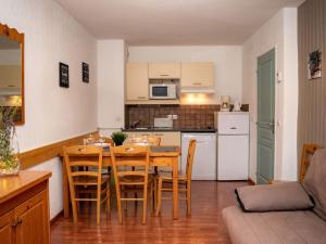 une cuisine et une salle à manger avec une table et des chaises dans l'établissement Appartement 3 Pièces pour 6 Personnes avec Piscine - Résidence Le Hameau du Puy, Superdévoluy - FR-1-504-455, à Superdevoluy