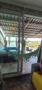Zimmer mit Glasschiebetür und Hängematte in der Unterkunft Vila Paisagem in Barra de Guaratiba