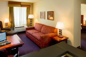a living room with a couch and a laptop on a table at Larkspur Landing Hillsboro-An All-Suite Hotel in Hillsboro