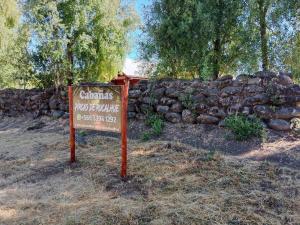 ein Schild vor einer Steinmauer in der Unterkunft Pircas de Rucalhue Cabins for 4 people and Jacuzzi in Quilaco + 6 Fotos