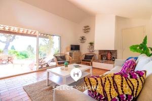ein Wohnzimmer mit Sofa und Tisch in der Unterkunft SELECT'SOHOME - Mas des Canadels - Maison pour 6 personnes avec jardin privé ! - RCMAS in Rayol-Canadel-sur-Mer