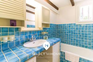 ein blau gefliestes Badezimmer mit Waschbecken und Badewanne in der Unterkunft SELECT'SOHOME - Mas des Canadels - Maison pour 6 personnes avec jardin privé ! - RCMAS in Rayol-Canadel-sur-Mer + 4 Fotos