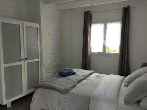 une chambre avec un lit blanc avec une fenêtre dans l'établissement Gite Les Jardins d'Harmonie, à Bourgneuf