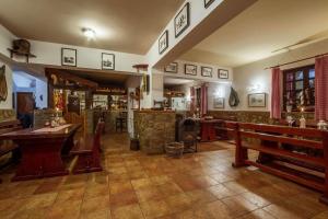 a restaurant with tables and benches in a room at Apartman Kačić in Sveti Ivan Dobrinjski