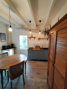 - une cuisine avec une table et des chaises en bois dans la chambre dans l'établissement Gite La Maison d'Harmonie, à Bourgneuf