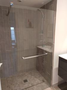 une douche avec une porte vitrée dans une salle de bain dans l'établissement Gite La Maison d'Harmonie, à Bourgneuf
