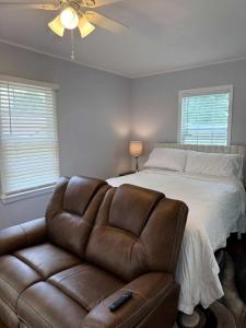 una camera con letto e divano in pelle marrone di Peaceful 1BR Home with Full Kitchen & Cozy Vibe a Lafayette