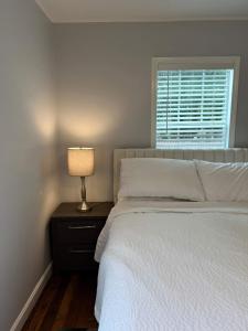 una camera da letto con un letto con una lampada e una finestra di Peaceful 1BR Home with Full Kitchen & Cozy Vibe a Lafayette