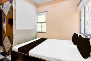 ein Schlafzimmer mit einem weißen Bett und einem Fenster in der Unterkunft Hotel O MD INTERNATIONAL GUEST HOUSE in Kalkutta + 21 Fotos