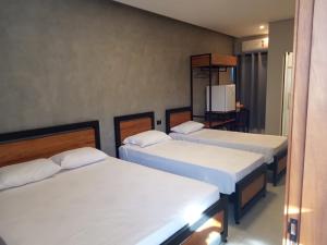 ein Zimmer mit drei Betten und einem Fernseher in der Unterkunft Hotel Maranhão in Ourinhos + 39 Fotos