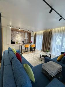 ein Wohnzimmer mit einer blauen Couch und einer Küche in der Unterkunft RODNIK guesthouse in Besqaynar