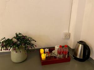 Una mesa con una bandeja con bebidas y un jarrón. en Avalon Villa Unawatuna, en Unawatuna