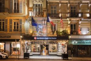 un edificio con banderas frente a una tienda en Best Western Plus Hôtel Massena Nice, en Niza