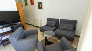 a living room with two chairs and a tv at SERRA E MESU Affittacamere in Magomadas