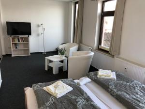 - un salon avec 2 lits et une télévision dans l'établissement Hotel & Restaurant Deutsches Haus Feldberg, à Feldberg