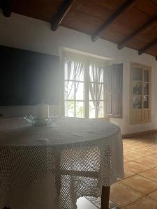 einen weißen Tisch in einem Zimmer mit Fenster in der Unterkunft Casa el Castaño in Aracena