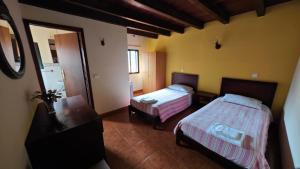 ein Hotelzimmer mit zwei Betten und einem Spiegel in der Unterkunft IlhaMontanha - Serras da Ilha in Jogo da Bola