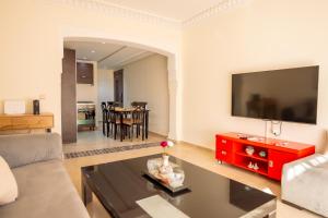 sala de estar con sofá y mesa roja en Luxury 2 BDRM in Hivernage with Pool and Garden, en Marrakech