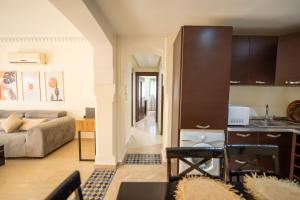 Una cocina y una sala de estar con un sofá y una mesa. en Luxury 2 BDRM in Hivernage with Pool and Garden, en Marrakech