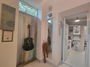 un couloir avec une guitare suspendue sur un mur dans l'établissement Artsy entire House, fully equipped, 2 rooms, 2 beds, parking, all to yourself!, à Bucarest 47 autres photos