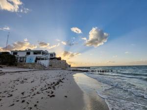- une vue sur la plage avec une maison et l'océan dans l'établissement Beach Villa Seaside Sunset Haven Nature & Chill, à Chuburná