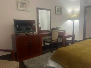 a bedroom with a desk with a television and a mirror at Grand Cleopatra Hotel-Luxor in Luxor