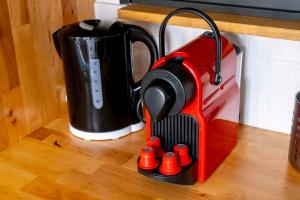 Ein rot-schwarzes Küchengerät auf der Arbeitsfläche neben einem Mixer. in der Unterkunft Le charme de la place Saint-Sauveur in Caen