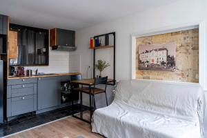 ein Schlafzimmer mit Bett und Tisch und eine Küche in der Unterkunft Le charme de la place Saint-Sauveur in Caen