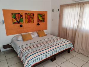 - une chambre avec un grand lit orné de peintures murales dans l'établissement Beach Villa Seaside Sunset Haven Nature & Chill, à Chuburná