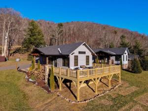 a house with a large deck in the grass at Valley View in Banner Elk