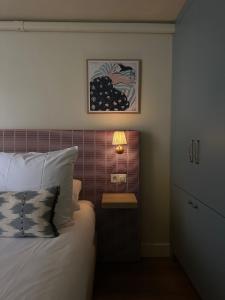 a bedroom with a bed and a table with a lamp at Hotel Atlas Vondelpark in Amsterdam
