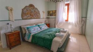 a bedroom with a bed and a table and a window at SERRA E MESU Affittacamere in Magomadas