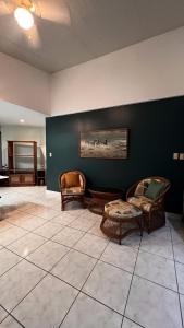 - un salon avec deux chaises et un tableau mural dans l'établissement Quinta La Vita Turrubares, à San Juan de Mata 6 autres photos