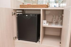 a black refrigerator inside of a kitchen cabinet at Estelar Cartagena de Indias Hotel y Centro de Convenciones in Cartagena de Indias