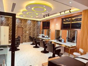 una peluquería con una barbería con sillas negras en Glory Regency Hotel, en Yuba