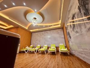 Una sala de espera con sillas verdes y un techo en Glory Regency Hotel, en Yuba