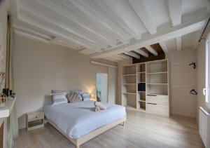 a bedroom with a white bed with a teddy bear on it at Cozy T2 - Quartier de Nantilly - Saumur in Saumur