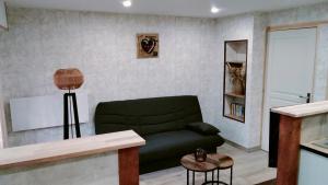 a living room with a green couch and a table at Jujuouragan 2 in Saint Die