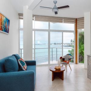 un salon avec un canapé bleu et une grande fenêtre dans l'établissement Casa Orilla Lodge, à Huamboya 2 autres photos