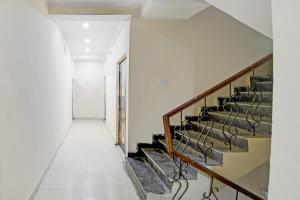 a hallway with stairs in a building at SPOT ON The Royal Inn in Kakarmatha