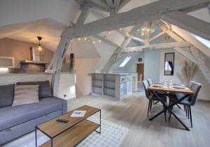 a living room with a blue couch and a table at Cozy T2 - Quartier de Nantilly - Saumur in Saumur