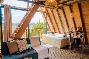 Habitación con bañera, sofá y mesa. en Cabañas con jacuzzi y chimenea - Casa Floral, Marinilla, en Marinilla