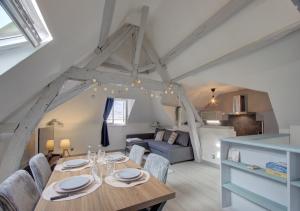 a dining room and living room with a table and chairs at Cozy T2 - Quartier de Nantilly - Saumur in Saumur +3 photos