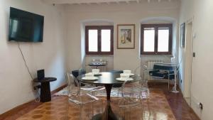 阿雷佐Maison Vasari - Centro Storico di Arezzo的一间带桌椅和电视的餐厅