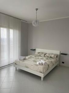 - une chambre blanche avec un lit et un lustre dans l'établissement Respiro di luna, à Pescopagano